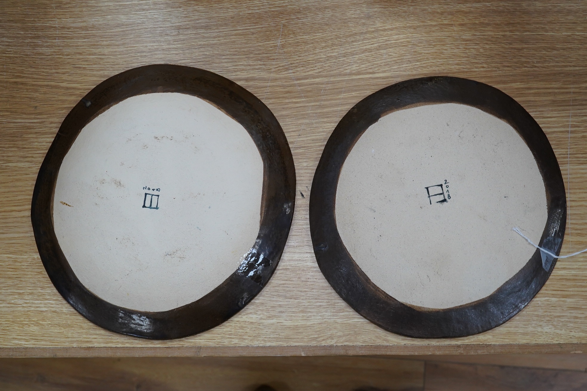 A pair of Eva Hernandez pottery plates, 26cm. Condition - good